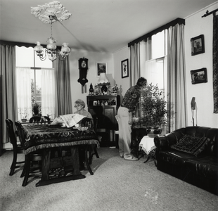 108276 Interieur van een huis (voormalige hovenierswoning) aan de Notebomenlaan te Utrecht: woonkamer, met de bewoners.